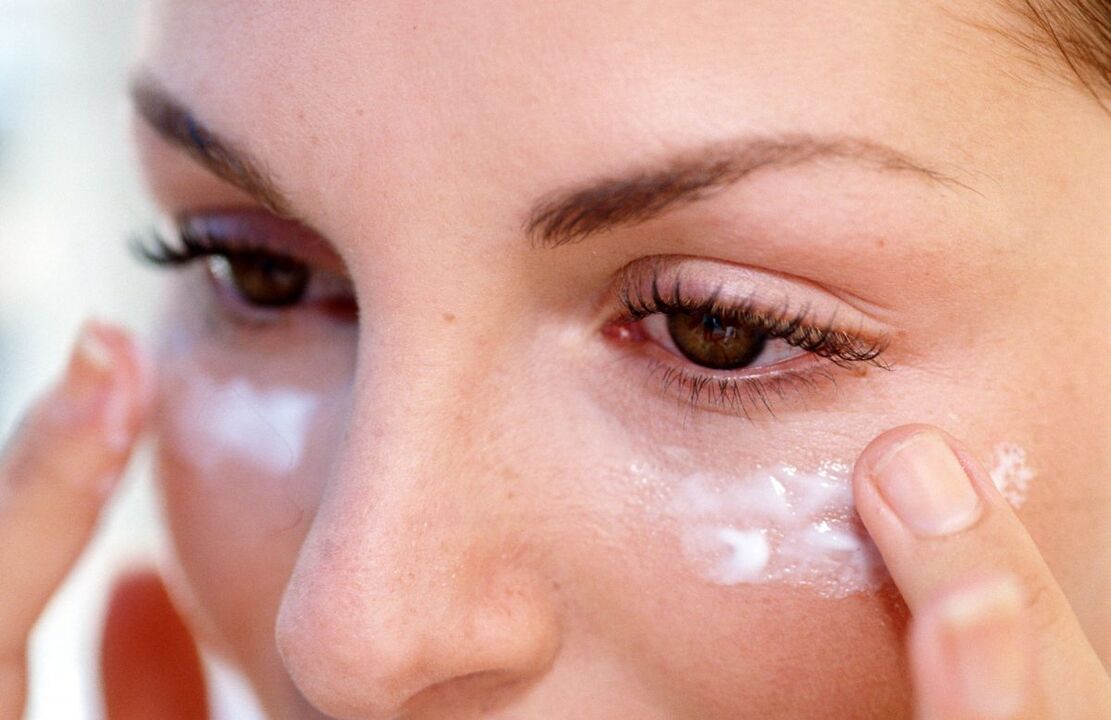 applying cream to rejuvenate the skin around the eyes